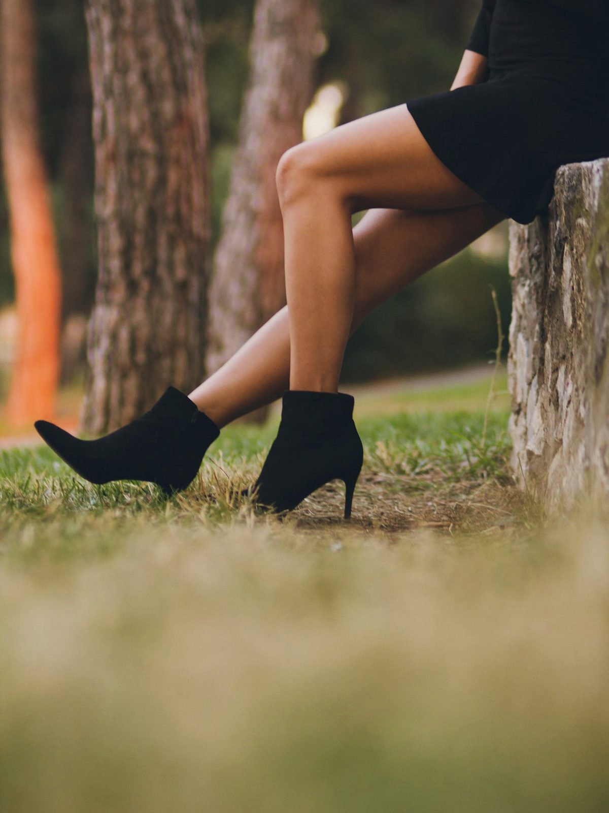 Black leather ankle boots in a forest clearing